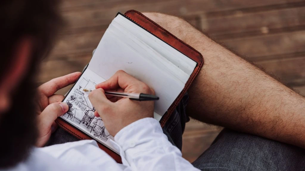 A handwritten notebook logging tracked side hustle income, sitting open on a desk.